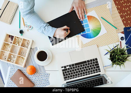 High angle view of unrecognizable creative graphic designer working with drawing tablet while working on new project Stock Photo