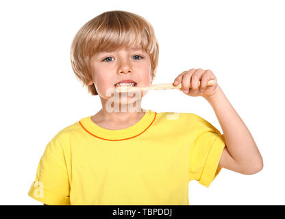Cute little boy brushing teeth on white background Stock Photo