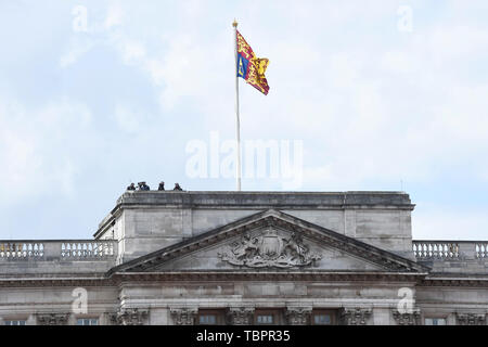 London, UK.  3 June 2019.  The Royal Standard flies above security officers on the roof of Buckingham Palace who await the arrival of Marine One, the helicopter carrying Donald Trump, on day one of his State Visit.  He will meet The Queen before commencing a variety of other engagements over the next three days.  Credit: Stephen Chung / Alamy Live News Stock Photo