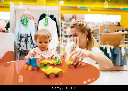 Mother with her little girl playing in kids store Stock Photo