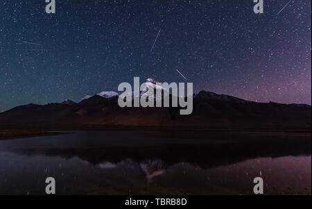 Few people photographed this seat of Zhuomu Razi, filming the stars skillfully encounter an early small explosion of the Orion meteor shower, the meteors constantly cut through the sky, skimming the peaks unusually brilliant and beautiful! One arrow and seven stars, only this one. Stock Photo