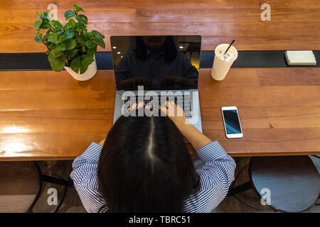 Freelancer using laptop while working on wooden table Stock Photo