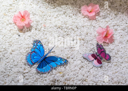 Paper butterflies on white stones Stock Photo