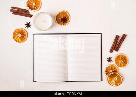 Notepad candle and autumn spices on white table. Stock Photo