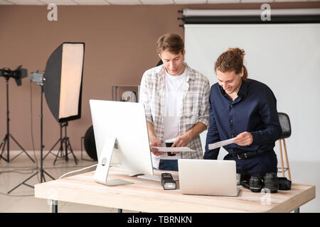Professional photographers working in modern studio Stock Photo