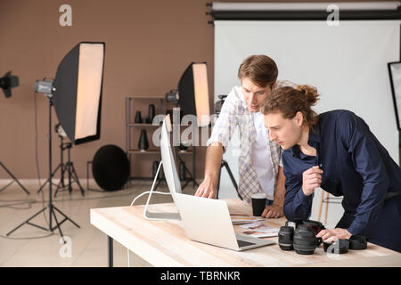 Professional photographers working in modern studio Stock Photo