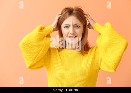 Portrait of stressed mature woman on color background Stock Photo