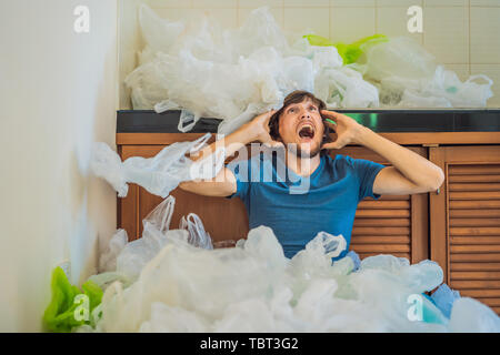 The man used too many plastic bags that they filled up the entire kitchen. Zero waste concept. The concept of World Environment Day Stock Photo