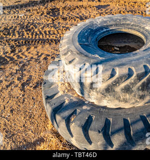 Square Old and dirty rubber tires stacked on top of each other viewed on a sunny day Stock Photo