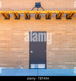 Square Facade of a building with gray door and brick exterior wall Stock Photo