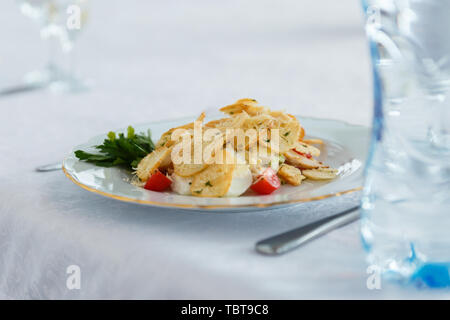 Snack in the restaurant. The salad on the plate with Cutlery on a light background Stock Photo