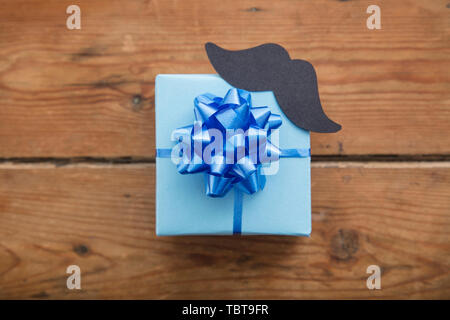 Fathers day blue wrapped gift with paper mustache. Happy father's day background Stock Photo