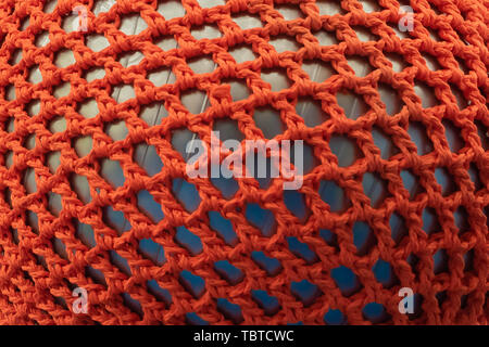 Rubber ball, covered with a red wicker mesh. Abstract texture of multi-colored woven fabrics. Creative vintage background Stock Photo