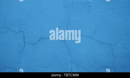 The crack on the plastered wall painted blue. Background, texture. Stock Photo