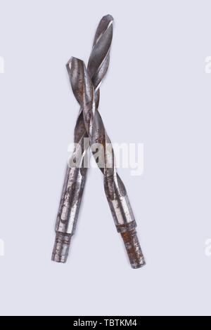 Rusty drill bits over white background. Two old drill bits, vertical image. Stock Photo