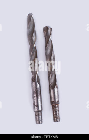 Old drill bits, top view. Used metal tools isolated on white background. Stock Photo