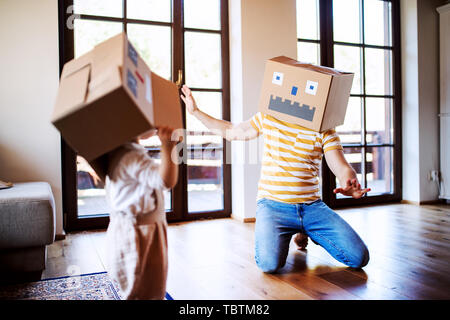 A toddler girl with father playing indoors at home. Stock Photo