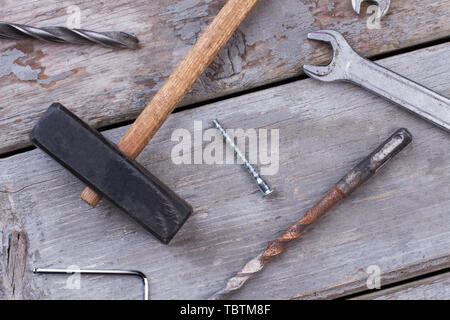Construction tools on wooden background. Hammer, spanner, screws and drill bits on old wooden boards. Stock Photo