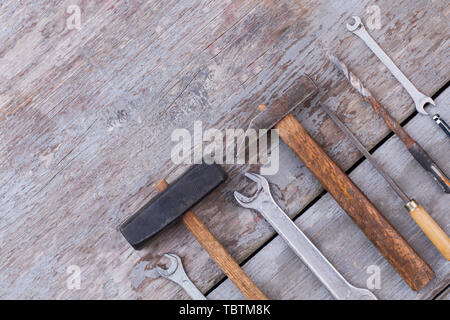 Set of carpenters tools on wooden background. Old hammer, spanners, screwdriver and drill bit. Space for text. Stock Photo