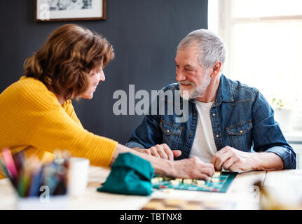 Senior couple playing board games in community center club. Stock Photo