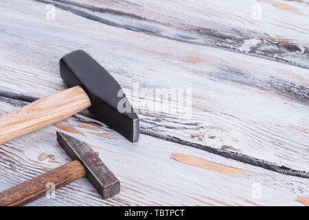 Two different hammers on wooden background. Big and small hammers on wooden boards. Space for text. Stock Photo