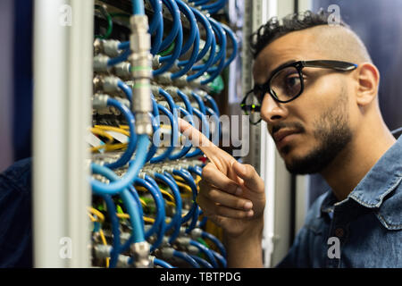 Middle-eastern network engineer checking cables Stock Photo
