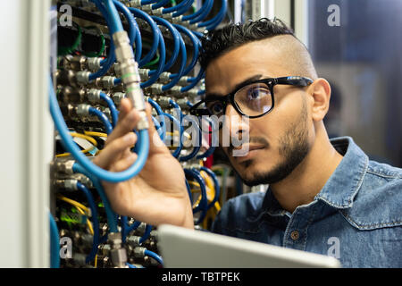 Technical engineer examining mainframe computer Stock Photo
