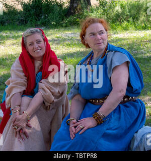 LUNI, MASSA CARRARA, ITALY – JUNE 2, 2019: Community event, Ancient Rome reenactment near Portus Lunae, genuine ancient settlement. Two women. Stock Photo