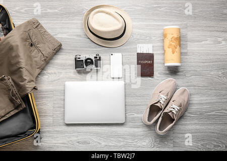 Male clothes and accessories with photo camera, mobile phone, laptop and travel objects on wooden background Stock Photo