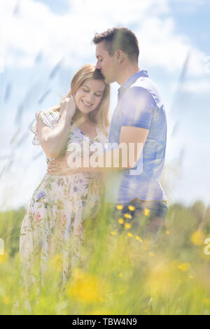 Young happy pregnant couple hugging in nature. Stock Photo