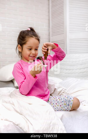 Sick little child girl pouring antipyretic syrup for kid in bed Stock Photo