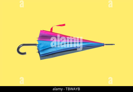 Multicolored umbrella on a yellow background. Stock Photo