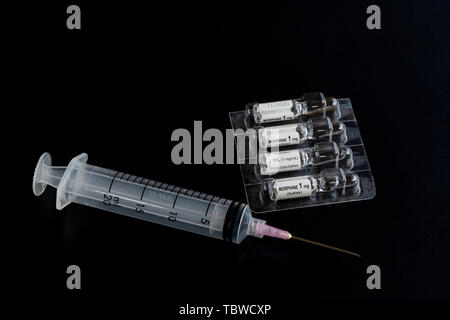 Close-up of liquid morphine sulphate glass vial 1 MG/ML for injections or infusion and syringe Stock Photo