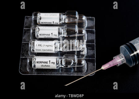 Close-up of liquid morphine sulphate glass vial 1 MG/ML for injections or infusion and syringe Stock Photo