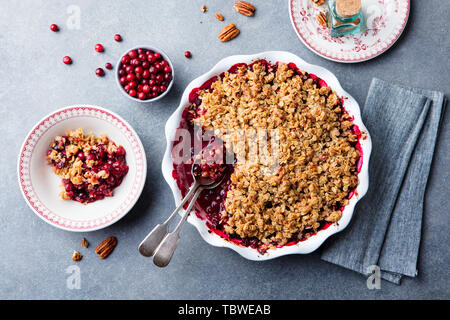 Cherry, red berry crumble in baking dish. Grey stone background. Top view.