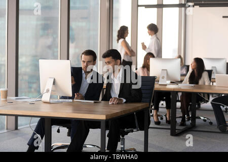 Diverse people working on computers in coworking space Stock Photo