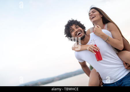 Smiling happy couple having fun on the beach. Holidays, vacation, love and friendship concept