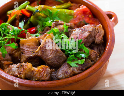 Portrait of cooked gyuvech dish of bulgarian cuisine of beef  with vegetables at clay pot Stock Photo