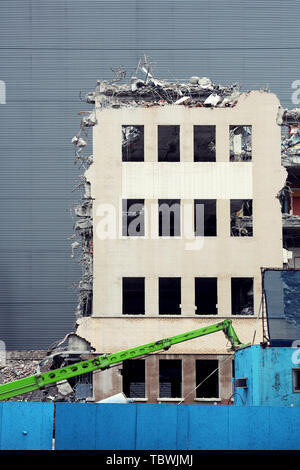 Building demolition with hydraulic excavator in an urban construction site Stock Photo