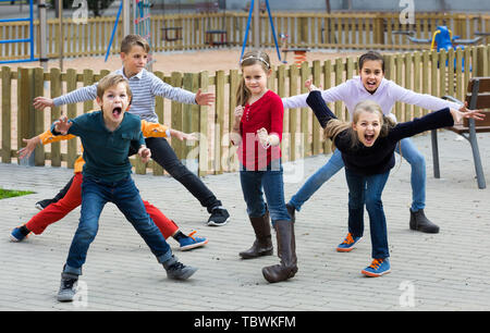 happy russian children showing different figures during game in playground outdoors Stock Photo