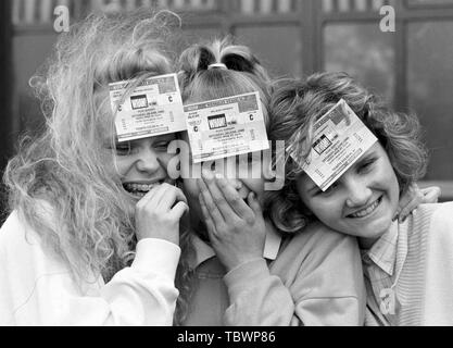 Wham! fans Jo Sayer (l), 16, and sister Katie, 13, of Dulwich, London, with Sarah Randell, 16 (r), of Beckenham, Kent, at Wembley Stadium, where they were among the first to receive tickets for the group's farewell concert at the stadium on June 28th. Stock Photo