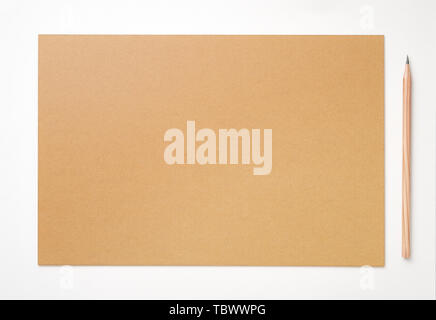 A pencil and a piece of yellow kraft paper on a white background Stock Photo
