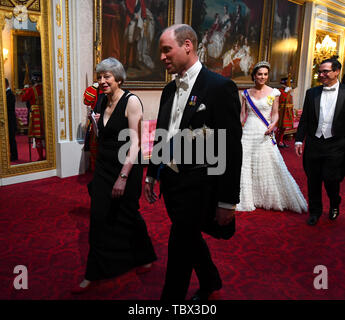 Prime Minister Theresa May and the Duke of Cambridge, followed by the Duchess of Cambridge and United States Secretary of the Treasury, Steven Mnuchin, as they arrive through the East Gallery during the State Banquet at Buckingham Palace, London, on day one of the US President's three day state visit to the UK. Stock Photo