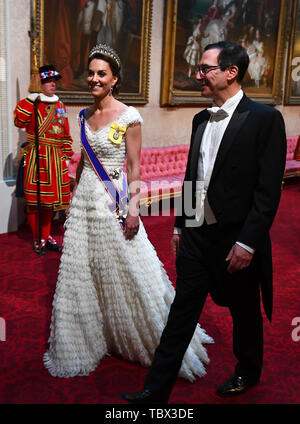 The Duchess of Cambridge and United States Secretary of the Treasury, Steven Mnuchin arrive through the East Gallery during the State Banquet at Buckingham Palace, London, on day one of the US President's three day state visit to the UK. Stock Photo