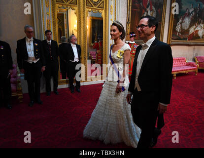 The Duchess of Cambridge and United States Secretary of the Treasury, Steven Mnuchin arrive through the East Gallery during the State Banquet at Buckingham Palace, London, on day one of the US President's three day state visit to the UK. Stock Photo