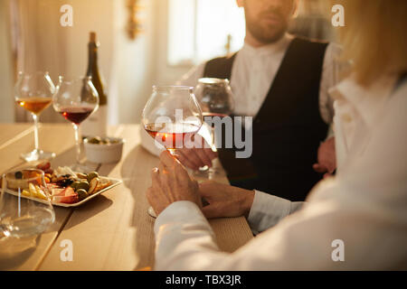 Mid section closeup of two professional sommeliers evaluating wine during tasting session in sunlight, copy space Stock Photo