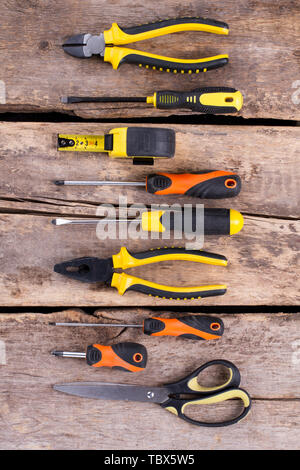 Construction tools set on old wooden background. Rustic wooden boards with various building instruments, top view. Home repair concept. Stock Photo
