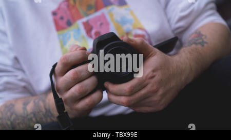 Young man photographer holds camera. Photographer concept. Stock Photo