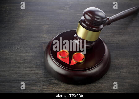 Wedding rings hammer of a judge on a wooden background. Divorce proceedings Stock Photo