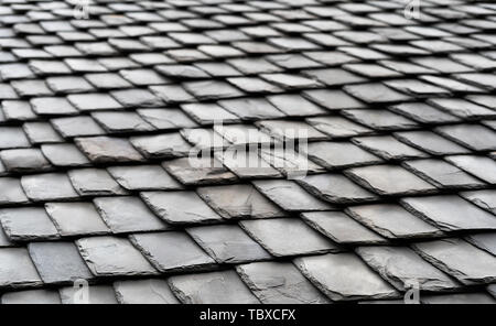 Aged black slate roof tiles background. Perspective view. Stock Photo